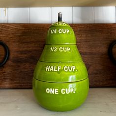 three green pear shaped bowls with the words half cup on them sitting next to each other