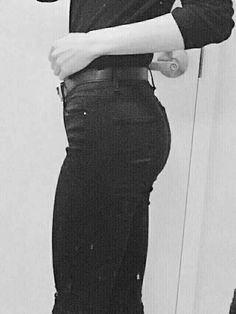 black and white photograph of a woman in high waist jeans with her hand on her hip