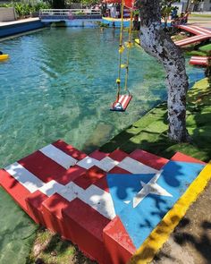 an american flag painted on the ground next to a tree and water park with swings