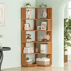 a wooden book shelf sitting on top of a hard wood floor next to a table