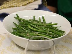 a white bowl filled with green beans on top of a table