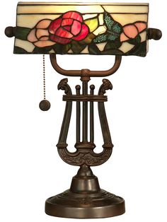 a stained glass lamp on top of a metal stand