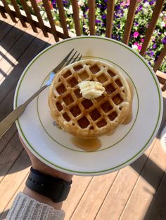 a person holding a plate with a waffle on it