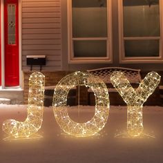 lighted letters spelling joy in front of a house