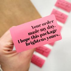 a person holding a pink piece of paper with words on it that say your order made my day