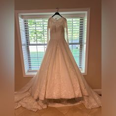 a wedding dress on display in front of a window