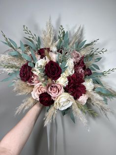 a bouquet of flowers is being held by someone's hand