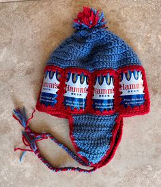 a blue and red knitted hat sitting on top of a floor