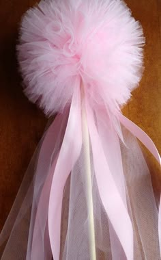 a pink tulle ball on top of a wooden table