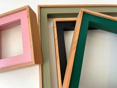 three different colored frames sitting next to each other on a wall with one missing the top