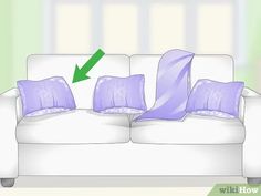 a white couch with purple pillows on it and an arrow pointing to the left side