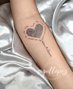 a woman's arm with a fingerprint heart tattoo on the left inner forearm