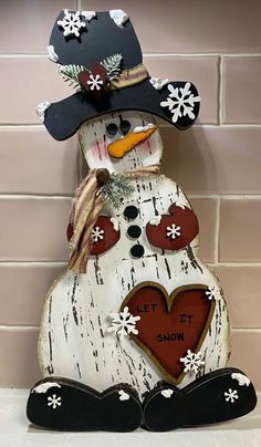 a wooden snowman with a hat and scarf