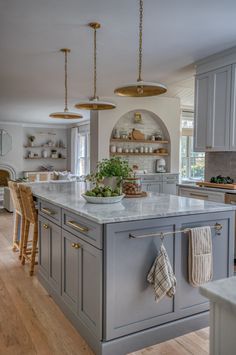 a large kitchen with an island in the middle and lots of counter space on one side