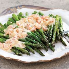 asparagus and crab salad on a white plate with a silver serving fork in it