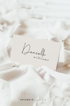 a name tag that reads danielle williams on top of a white bed sheet with ruffles