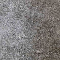 an area rug is shown with grey and white fur on the floor, as if it were carpeting