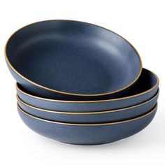 three blue bowls with gold rims stacked on top of each other in front of a white background