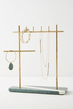 a jewelry rack with two necklaces and a cross on the top, in front of a white background