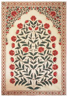 an intricately designed rug with red flowers and leaves on white ground, in the middle of