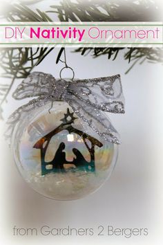 a christmas ornament with a nativity ornament hanging from a tree