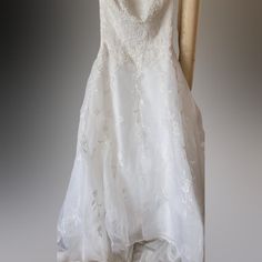 a white wedding dress hanging on a hanger