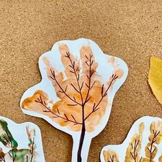 three leaf shaped stickers sitting on top of a table