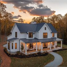 a large white house with lots of windows on the front and side of it at sunset