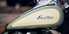 a close up view of the front end of a green and white motorcycle with an emblem on it