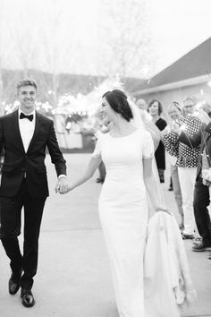 a newly married couple walking down the street with sparklers in the air behind them