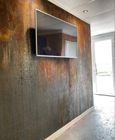 a tv mounted to the side of a wall in an empty room with peeling paint on it