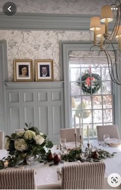 the dining room table is set with flowers and place settings for four people to sit at