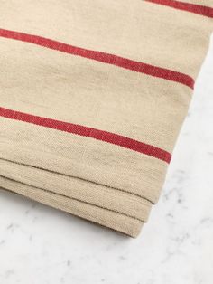 a close up of a cloth with red stripes on white marble counter top and floor