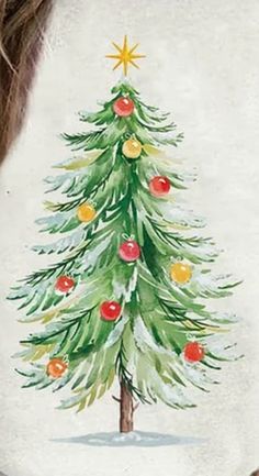 a woman wearing a white shirt with a christmas tree painted on the back of it