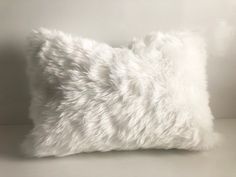 a white furry pillow on a white background