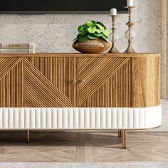 a wooden sideboard with a plant on top and two candles in the corner next to it