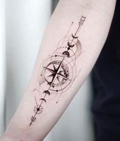 a compass tattoo on the arm with arrows and stars around it, as well as an arrow