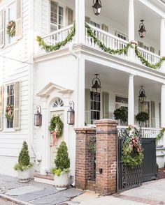 a white house decorated for christmas with wreaths