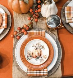 the table is set for thanksgiving dinner with pumpkins and gourds