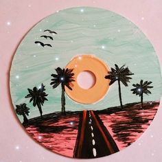 a painted disc with palm trees and a road