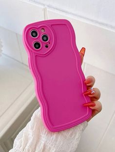 a woman holding a pink phone case in her hand