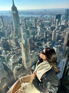 a woman standing on top of a tall building looking out at the cityscape