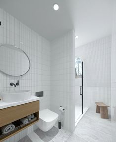 a bathroom with white tile walls and flooring