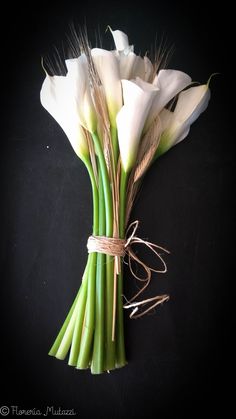 some white flowers are tied together on a black surface