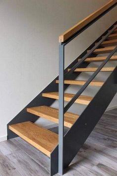 a wooden and metal staircase in an empty room