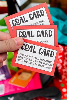 someone holding up two red and white cards with the words coal card written on them