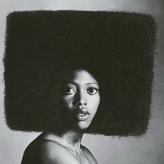 a woman with an afro on her head is shown in black and white photo,