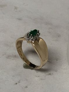 14kt Yellow Gold Lady's Diamond and Emerald Halo Ring consisting of a 6mm x 3mm Genuine Marquise Shape Emerald 1/4ct approx. total weight with 12-.02ct .25ct total weight full cut round brilliant diamonds surrounding center Emerald as a Halo. All stones are prong set in wide graduating concave mounting measuring 8mm to 4mm of bright polished 14kt Yellow Gold in finger size 9. This item would Retail for $975.00 Stamped 14k Jewelry For Promise Ring And May Birthstone, 14k Gold Diamond Cut Ring For May Birthstone, Stamped 14k Gold May Birthstone Ring, Fine Jewelry 14k Stamped May Birthstone Ring, 14k Gold Jewelry With Halo Setting For May Birthstone, May Birthstone Diamond Jewelry Stamped 14k, Classic Marquise Cut May Birthstone Jewelry, 14k Yellow Gold Ring For May Birthstone, Yellow Gold 14k Stamped May Birthstone Ring