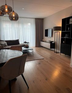 a living room filled with furniture and a flat screen tv on top of a wooden floor