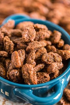 a blue bowl filled with gingerbread candied pecans